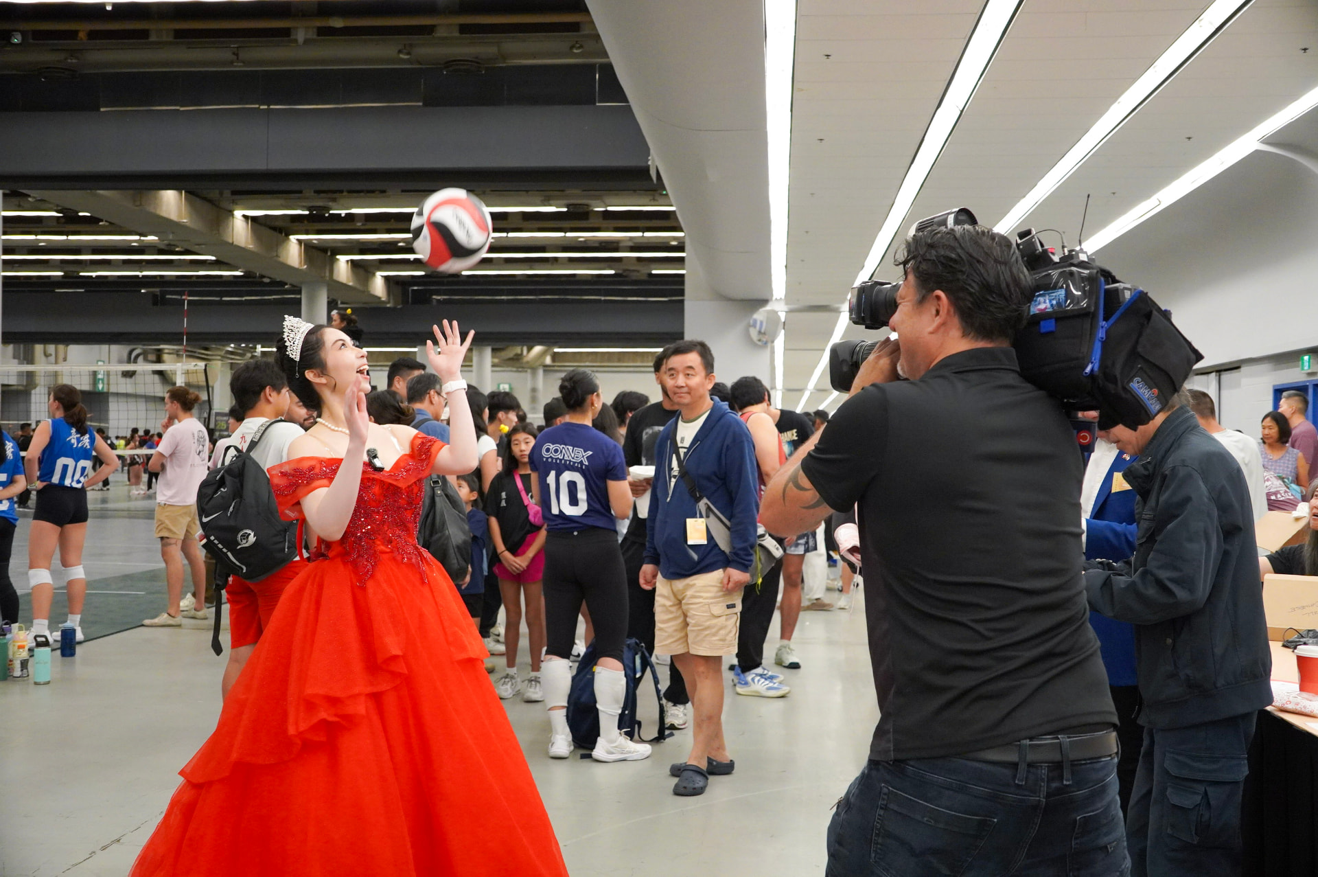 Louese Hu on the NACIVT volleyball court with a television camera crew