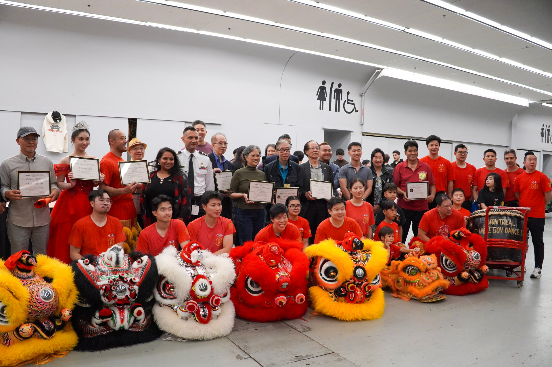 Community leaders and lion dance performers holding certificates of appreciation at NACIVT